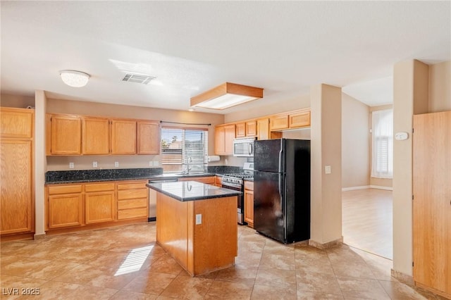 kitchen featuring a kitchen island, light tile patterned flooring, appliances with stainless steel finishes, and sink