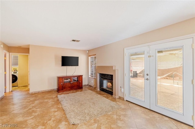 living room with washer / clothes dryer and french doors