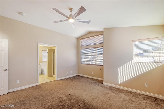 unfurnished bedroom with light carpet, ensuite bath, vaulted ceiling, and ceiling fan