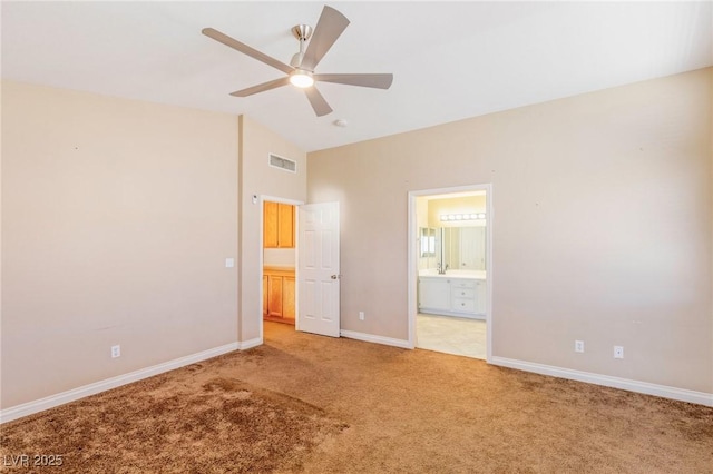 unfurnished bedroom with lofted ceiling, ensuite bath, ceiling fan, and carpet