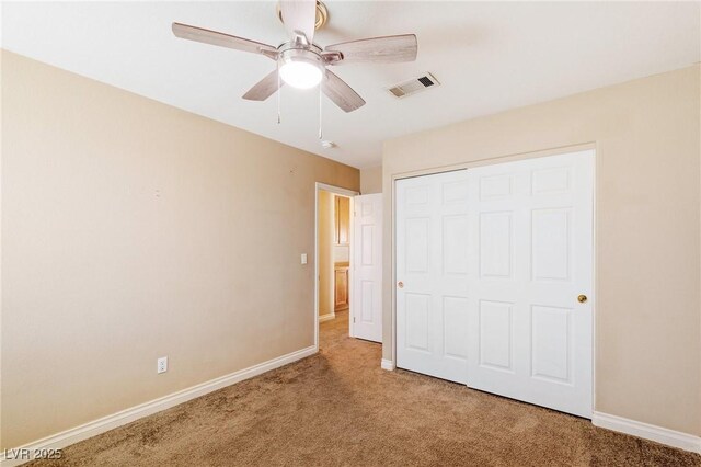 unfurnished bedroom with carpet floors, a closet, and ceiling fan