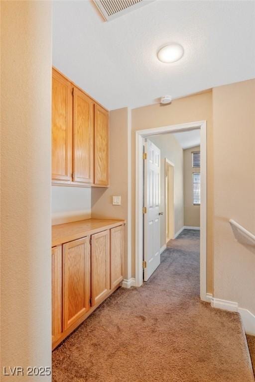 hallway featuring light colored carpet