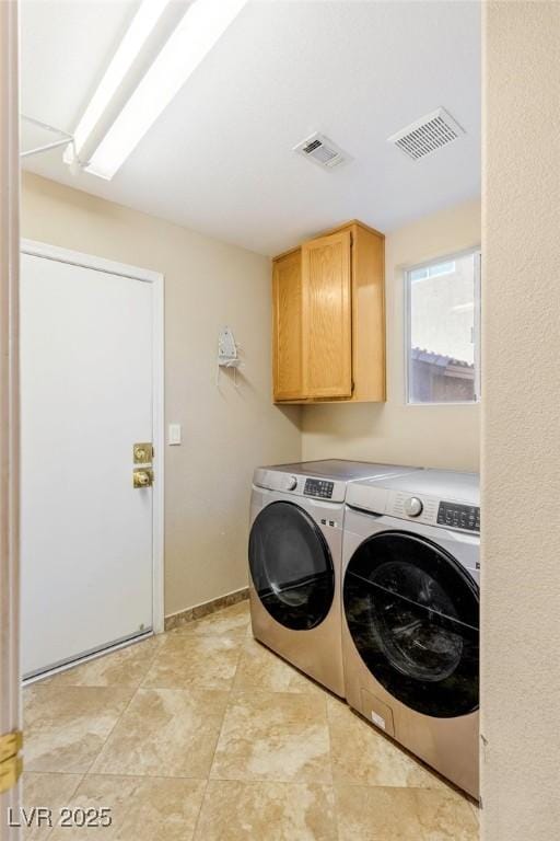 laundry room with separate washer and dryer and cabinets