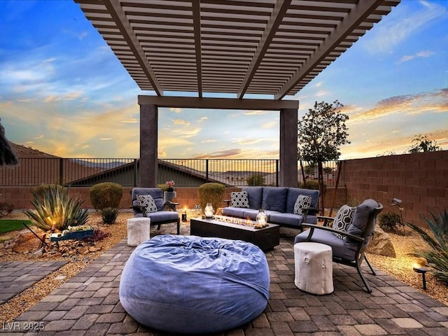 patio terrace at dusk with an outdoor living space with a fire pit and a pergola