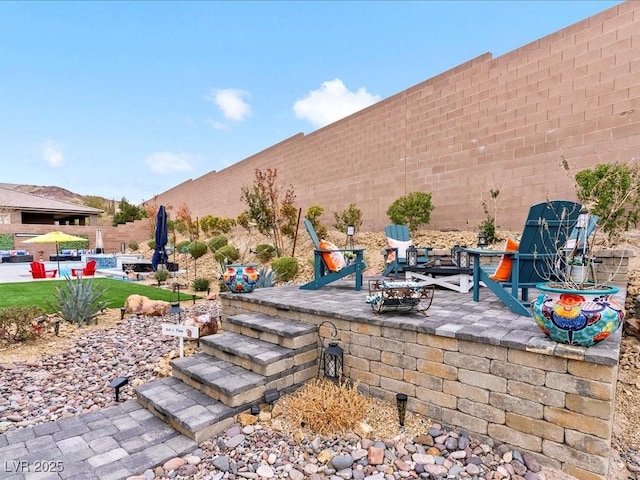 view of patio featuring a pool and a fire pit