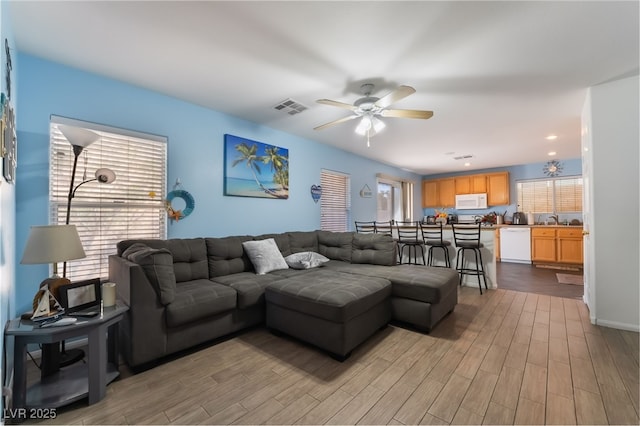 living room featuring ceiling fan and light hardwood / wood-style flooring