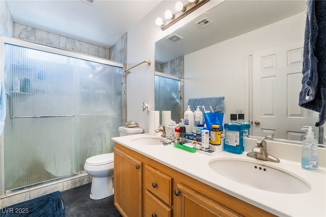 bathroom featuring a shower with door, vanity, tile patterned flooring, and toilet