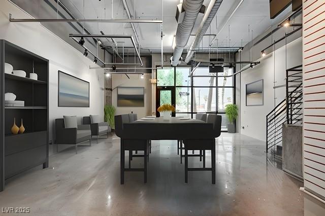 miscellaneous room featuring concrete flooring and a towering ceiling