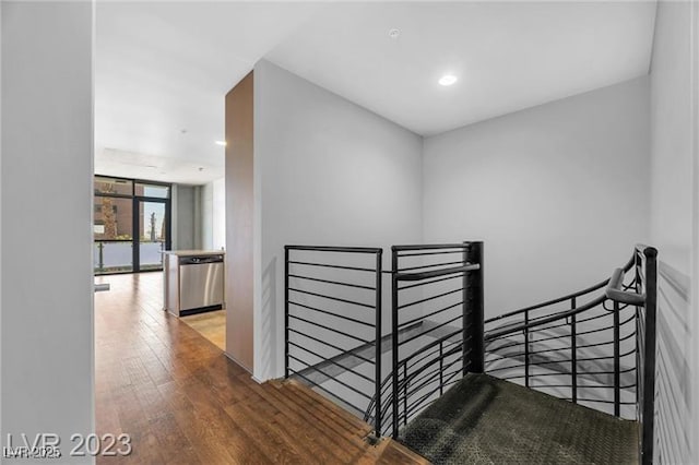 stairway featuring a wall of windows and wood-type flooring