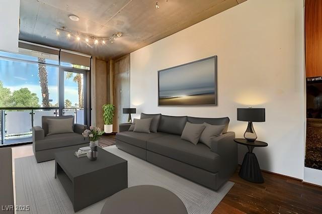 living room featuring rail lighting, wood-type flooring, and floor to ceiling windows