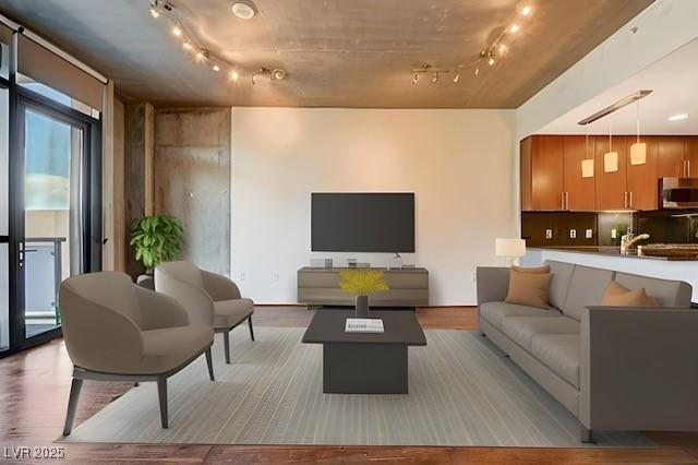 living room with track lighting, a wall of windows, and light hardwood / wood-style flooring