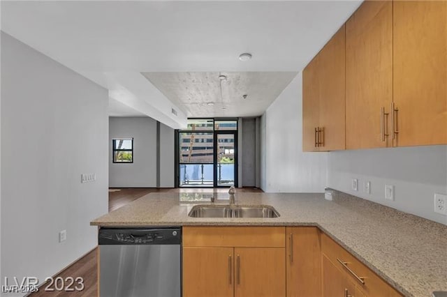 kitchen featuring light stone countertops, dishwasher, sink, and kitchen peninsula