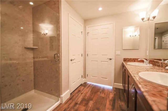 bathroom with wood-type flooring, vanity, and walk in shower