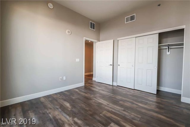 unfurnished bedroom featuring dark hardwood / wood-style flooring and a closet