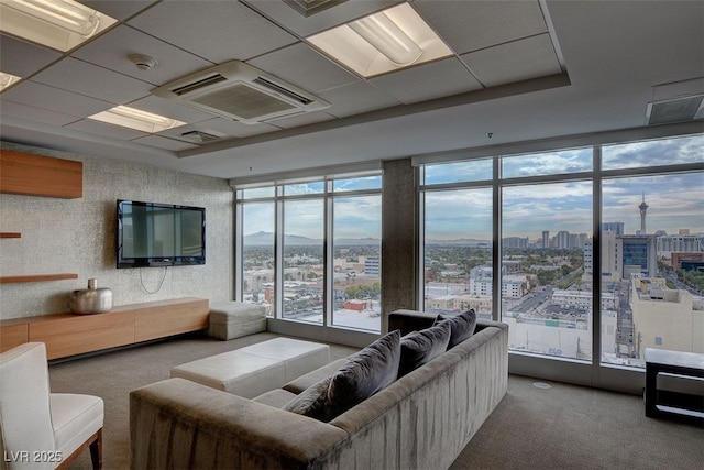 living room featuring carpet and a drop ceiling