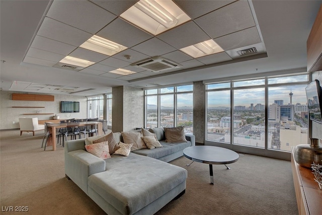 carpeted living room with floor to ceiling windows and a paneled ceiling