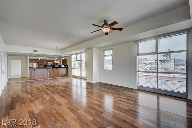 unfurnished living room with hardwood / wood-style flooring and ceiling fan