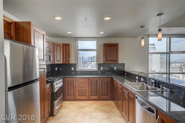 kitchen featuring a healthy amount of sunlight, appliances with stainless steel finishes, decorative light fixtures, and sink