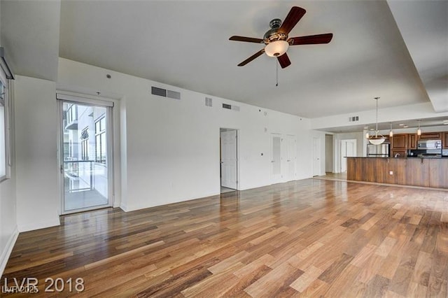 unfurnished living room with ceiling fan and wood-type flooring