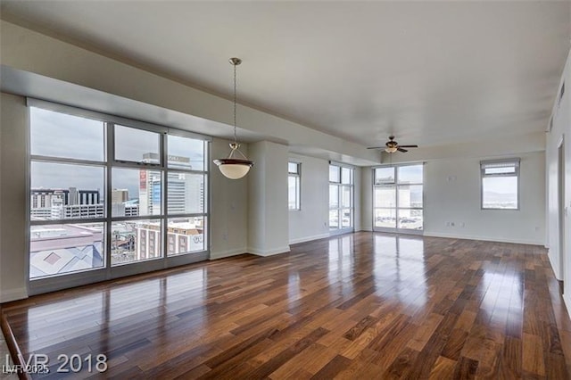 unfurnished living room with dark hardwood / wood-style floors and ceiling fan