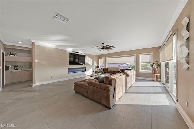 tiled living room with crown molding and ceiling fan