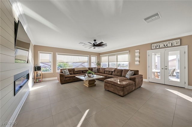 living room featuring crown molding, light tile patterned flooring, and french doors