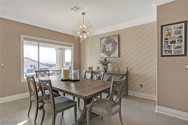 tiled dining space featuring crown molding and a chandelier