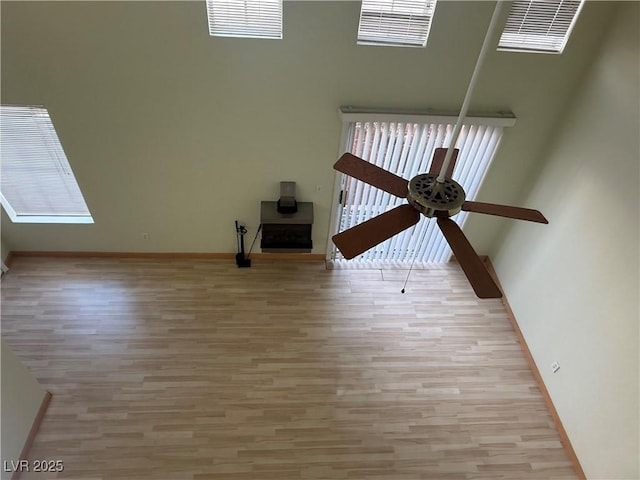 unfurnished living room featuring ceiling fan and light wood-type flooring