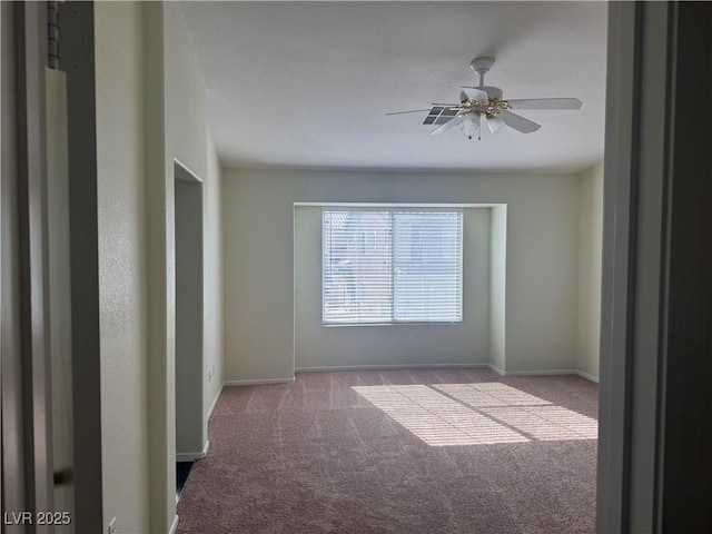 spare room featuring light carpet and ceiling fan