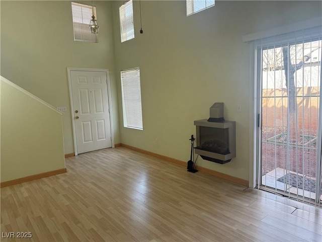 entrance foyer featuring a chandelier, light hardwood / wood-style floors, and a high ceiling