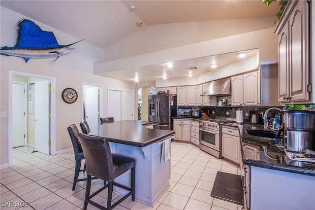 kitchen with light tile patterned floors, a breakfast bar, extractor fan, sink, and stainless steel appliances