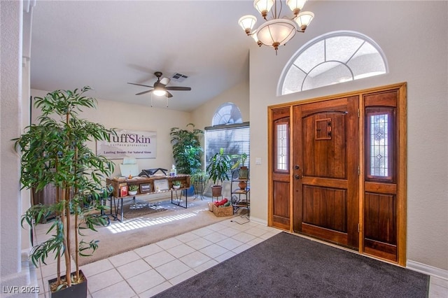 carpeted foyer entrance featuring ceiling fan with notable chandelier and high vaulted ceiling