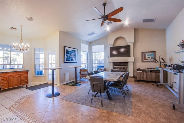 tiled dining space with high vaulted ceiling and ceiling fan with notable chandelier