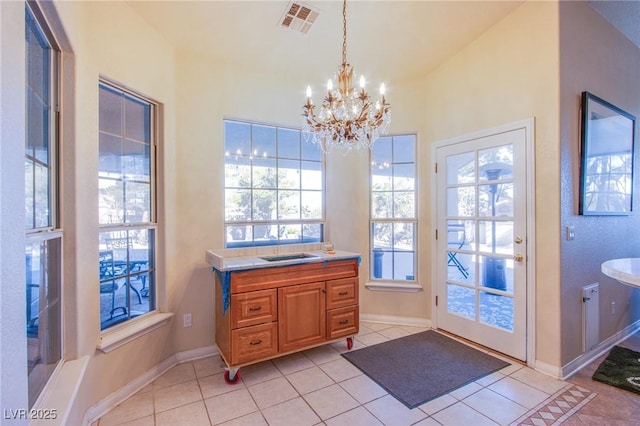 entryway featuring light tile patterned floors and a notable chandelier