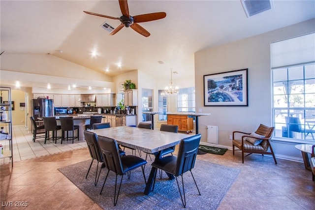 tiled dining space with ceiling fan with notable chandelier, vaulted ceiling, and a wealth of natural light