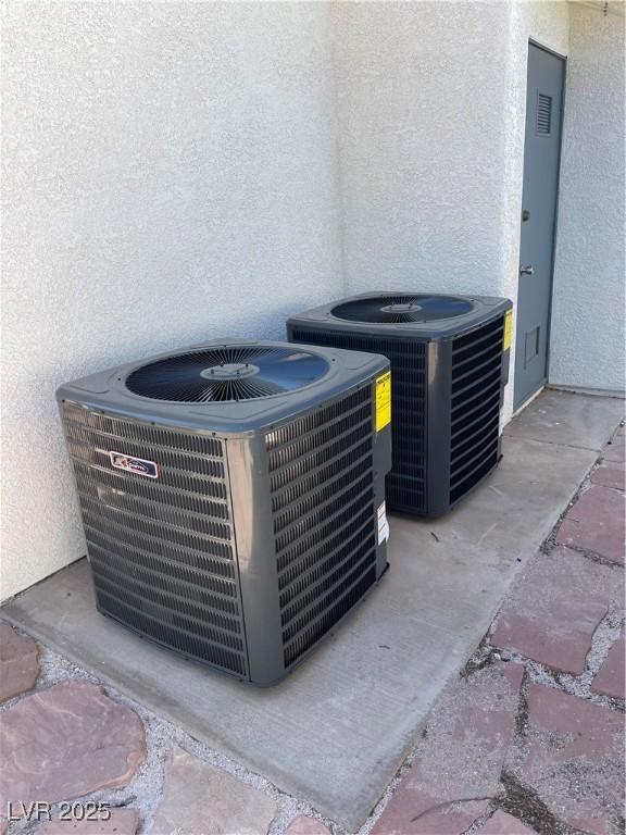 details featuring stucco siding and central air condition unit