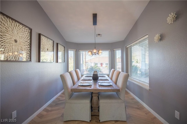 dining area featuring a chandelier, vaulted ceiling, visible vents, and baseboards