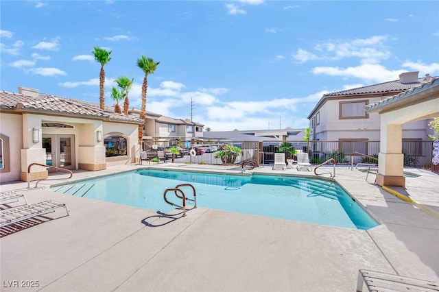 view of swimming pool with a patio and french doors