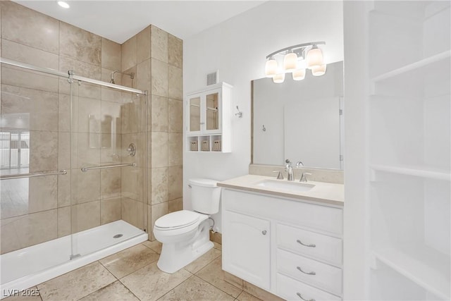 bathroom featuring vanity, a shower with shower door, tile patterned floors, and toilet