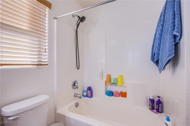 bathroom featuring tiled shower / bath combo and toilet