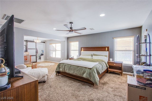 carpeted bedroom with multiple windows and ceiling fan