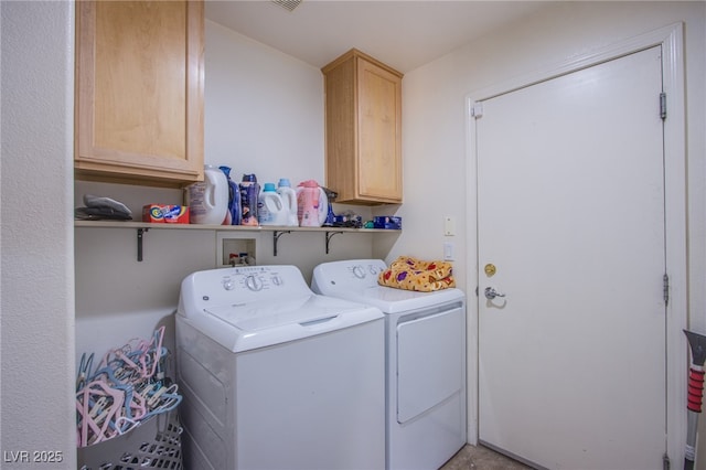 laundry area featuring washer and clothes dryer and cabinets