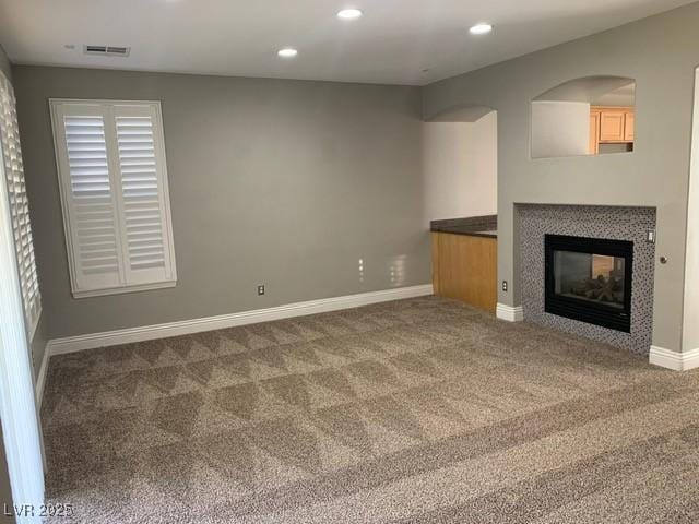 unfurnished living room featuring carpet flooring and a fireplace