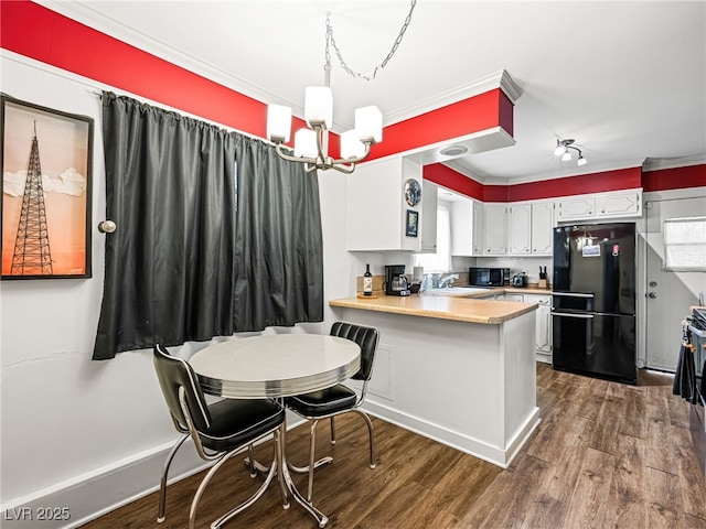 kitchen with sink, white cabinetry, dark hardwood / wood-style flooring, kitchen peninsula, and black appliances