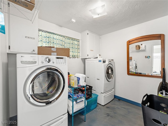 laundry area featuring a textured ceiling, cabinets, and washing machine and clothes dryer