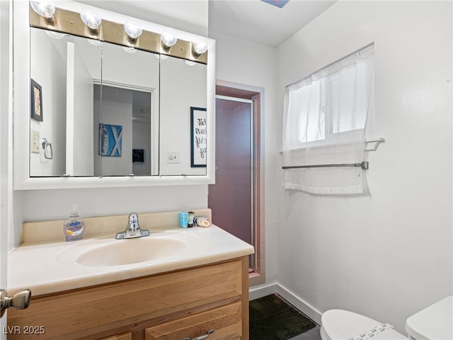 bathroom with vanity, a shower, and toilet