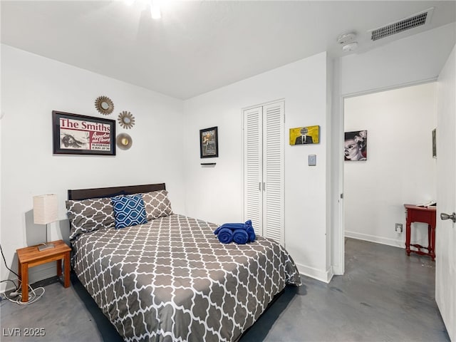 bedroom with concrete flooring and a closet