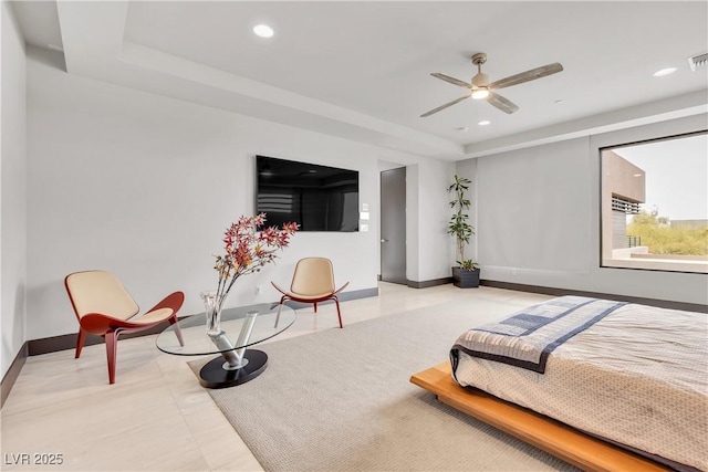 bedroom featuring a raised ceiling and ceiling fan