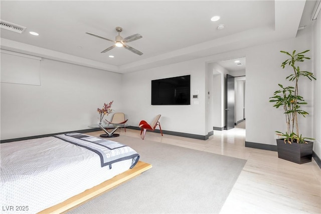 bedroom with a tray ceiling and ceiling fan