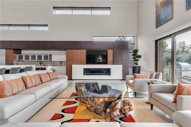 living room with light hardwood / wood-style flooring and a high ceiling